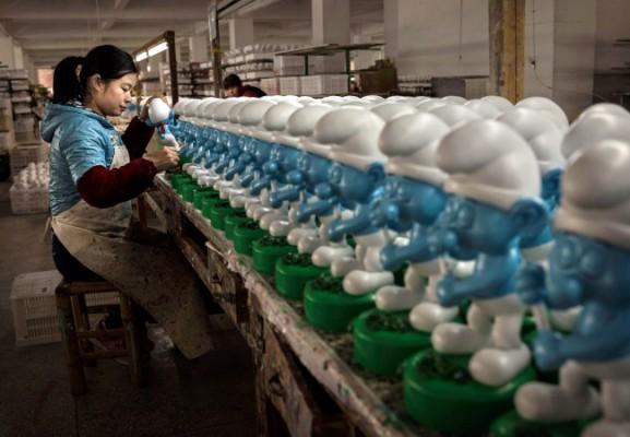 En kinesisk arbetare målar keramiksmurfar på en fabrik i Fujianprovinsen i Kina, 7 december 2014. (Kevin Frayer/Getty Images)