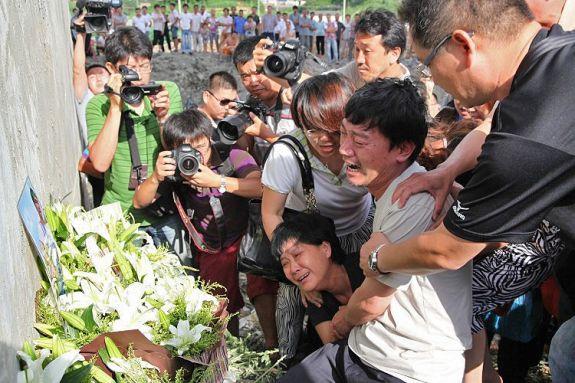Kinesiska kvinnor sörjer sina anhöriga som dog i tågolyckan i Wenzhou. En av Kinas officiella tidningar anklagade myndigheterna för "arrogans" i hanteringen av olyckan och allmänheten har också visat sin indignation på offentliga platser. (Foto: STR/AFP/Getty Images)
