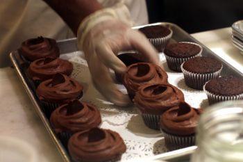 En bagare garnerar muffins den 19 april 2011 i New York. (Foto: Spencer Platt/Getty Images)