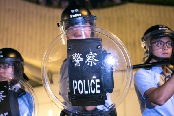Prodemokratiska demonstranter drabbar samman med polis i sina försök att blockera Lung Wo Road, en av de större vägarna genom Hongkong, som ett svar på att polisen tog bort barrikader och öppnade en ockuperad väg, 14 oktober 2014. (Benjamin Chasteen/Epoch Times)