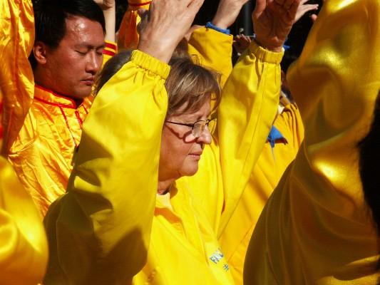 Margareta Nordh gör Falun Gong-övningar framför Kulturpalatset i Warszawa. Hon ser tydliga likheter mellan judeförföljelsen som plågade Polen och förföljelsen av Falun Gong i Kina. (Foto: Hans Bengtsson/Epoch Times)