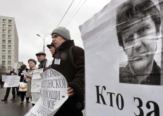 RYSSLAND, Moskva : Ryska aktivister för mänskliga rättigheter håller poträtt av före detta spion Alexander Litvinenko under protesten framför det ryska inrikesministeriet i Moskva den 15 december 2006. (Foto: AFP/Denis Sinyakov)