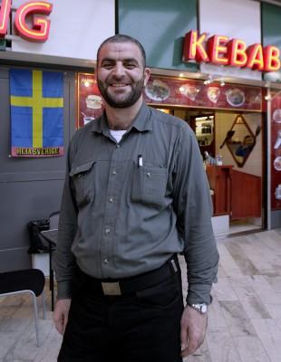 SVERIGE, Tensta: Ali Rasoul Jaber, en av de irakiska asylsökandena,  står i Tensta affärscentrum den 19 december 2006. Han ler glatt då han fick uppehållstillstånd i Sverige förra veckan. Han flydde från Bagdad i Irak där han arbetade som universitetsprofessor. Nu kan han planera för framtiden för sig själv och familjen med fru och två barn utan att behöva vara orolig för deras säkerhet. Han sålde sitt hus, sin bil och hustruns smycken för att betala för resan från Irak. Han arbetar nu i en elektronikbutik som en familjemedlem till honom sköter i Tensta affärscentrum. I november 2006 hade 1559 irakier begärt asyl i de skandinaviska länderna. (Foto: AFP/Sven Nackstrand)
