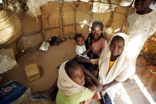 En flyktingfamilj i sitt tält på Sakalis flyktingläger i staden Nyala i Darfur. I Sudan finns fyra miljoner flyktingar och de flesta har kommit från Sudans södra trakter. En kvartsmiljon av dessa fyra miljoner har återvänt till sina hem efter 2006-års fredsavtalet enligt FN:s beräkningar. Efter många års stridigheter är det ett svårt och långsamt arbete att få flyktingarna återvända till sina hemtrakter. (Foto: AFP/Mustafa Ozer)
