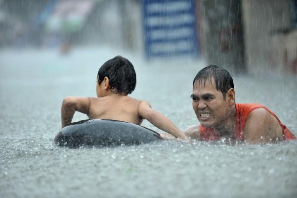 Den tropiska stormen Ketsana har orsakat stora översvämningar på Filippinerna. Här förs en filippinsk pojke i säkerhet i Quezon, en förort till Manila, den 26 september. (Foton: Jay Directo/ AFP)

