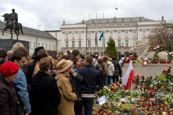 Folk lägger ner blommor och ljus vid presidentpalatset i Warsawa den 10 april efter att landets president och hans fru samt höga regeringstjänstemän omkommit i en flygplansolycka i Smolensk i Ryssland. (Foto: Adam Kielar/Epoch Times)
