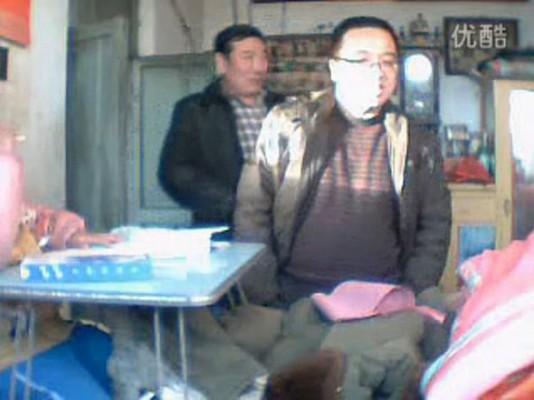 En video från internet tidigare i år, där Qu Huaqiang, bakom kameran, spelar in ett utbyte med lokala tjänstemän. Qu ses inte i bild. Han argumenterar om den ersättning han har rätt till efter att han blivit förlamad i en arbetsolycka. Qu sprängde nyligen sig själv framför ett kommunhus. (Skärmdump från internet)