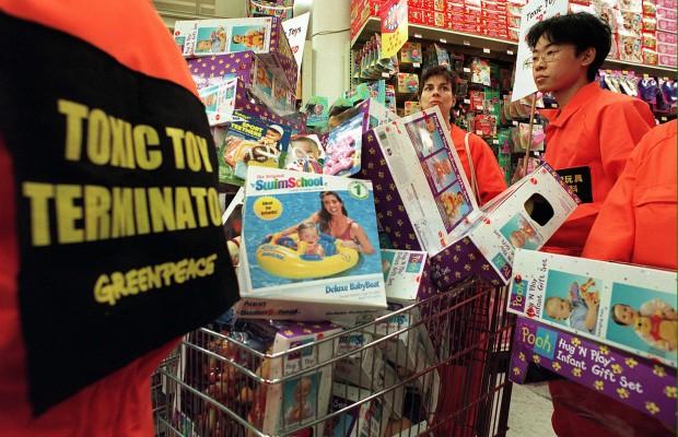 Greenpeace-aktivister uppmanar en Toys R Us butik i Hong Kong att ta bort de farliga leksakerna från butiken. Korgen är full av leksaker som innehåller PVC (polyvinylklorid), ett giftigt ämne som gör att plasten blir mjuk och smidig. (Foto: AFP/Frederic J. Brown)