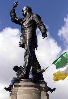 Två demonstranter nära Belfast viftar med den irländska flaggan vid statyn av Lord Carson, nära Belfast. (Foto: AFP / Paul Faith)