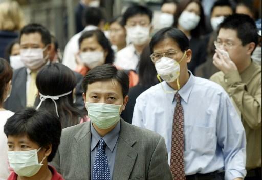 Bilden som är tagen i Hongkong den 31 mars 2003, bär folk munskydd för att skydda sig mot sars-epidemin på gatorna i Hongkong. Myndigheterna i Kina hade länge försökt dölja att viruset fanns i Kina, vilket avslöjades 2003 av den fria kinesiska tv-kanalen NTD Television, omkring tre veckor innan de kinesiska myndigheterna erkände smittan.  (Foto: Peter Parks/ AFP)