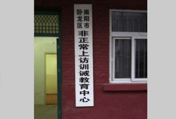 En kinesisk nätanvändare postade den här skylten på nätet för att identifiera ett interneringscenter i Nanyang i Henanprovinsen. På skylten står det "Utbildnings- och disciplincenter för onormalt rättssökande". (Weibo.com)