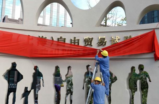 Arbetare dekorerar en port till Shanghai Waigaoqiaos frihandelszon inför det formella öppnandet den 29 september. I Kinas första frihandelszon ska man kunna ha fri tillgång till facebook, twitter och andra sajter som är förbjudna i resten av landet. (Foto: STR/AFP/Getty Images)
