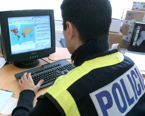 En spansk polisman tittar på en dator i samband med en undersökning om barnpornografi. (Foto: AFP/Spanska polisen/HO)