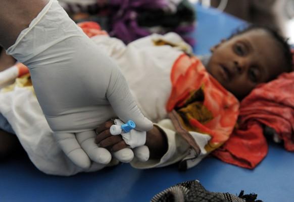 Fyra månader gamla Hamsa  undersöks av en läkare i en korridor på ett sjukhus i Mogadishu 16 augusti. Hamsa var enligt en läkare på plats i svår chock och lider av akut undernäring. (Foto: Roberto Schmidt/AFP)
