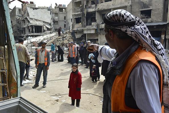 Palestinska flyktingar köar för att få hjälp av en lokal organisation i det belägrade flyktinglägret Yarmuk, söder om den syriska huvudstaden Damaskus, den 11 mars, är 2015. Lägret hade flera sjukhus. Yarmuk är nu ödelagt och endast omkring 40 000 personer återstår av de 150 000 palestinska och syriska människor som bodde i lägret innan den syriska konflikten bröt ut i mars 2011. Foto: AFP / Getty Images)