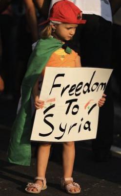 En liten flicka håller ett plakat med parollen "Frihet till Syrien" under en regimkritisk protest utanför den syriska ambassaden i den cypriotiska huvudstaden Nicosia den 31 juli. (Foto: Patrick Baz/AFP/Getty Images)