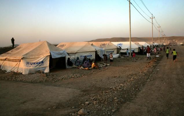 Syrisk-kurdiska flyktingar sitter utanför tälten som tillhandahålls av UNHCR vid Quru Gusik flyktingläger, 20 kilometer öster om Arbil, huvudstaden i den autonoma kurdiska regionen i norra Irak, den 27 augusti 2013. (Foto: AFP/Safin Hamed)