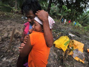 Överlevande sörjer intill sina döda anhöriga som lagts i påsar vid byn Munte Baru-Baru på Norra Pagaiön, som tillhör Mentawaiöarna i västra Sumatra, den 29 oktober, tre dagar efter att en jordbävning med magnituden 7,7 på Richterskalan triggat den tsunami som drabbade området (Foto: Bay Ismoyo/AFP/Getty Images)
