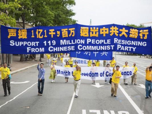 Falun Gong-utövare bär en banderoll som uppmärksammar att 119 miljoner kineser avsagt sig allt samröre med det kinesiska kommunistpartiet, vid en parad i Washington DC den 13 juli. (Foto: Edward Dai/The Epoch Times)
