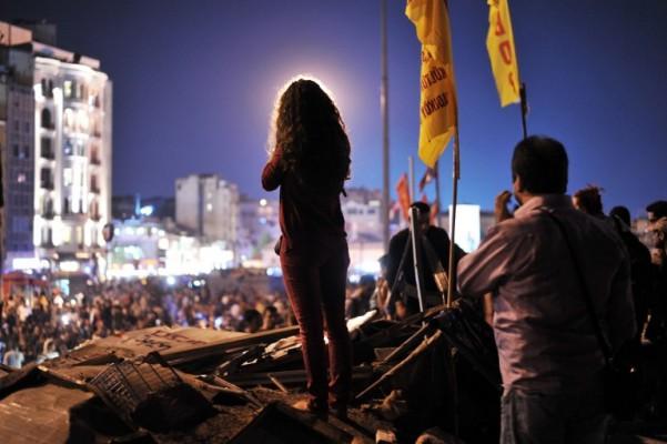 En kvinnlig demonstrant står på barrikaden vid Geziparken nära Taksimtorget den 14 Juni i Istanbul. Turkiets premiärminister Recep Tayyip Erdogan vädjade till demonstranterna att evakuera en Istanbul Park "i kväll", efter att ha lovat att avbryta ombyggnaderna. (Foto: Ozan Kose/AFP)
