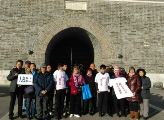 En grupp demonstranter i Peking den 9 december, 2014, håller upp banderoller om krav på mänskliga rättigheter, dagen innan den internationella människorättsdagen. (Skärmdump/Human Rights Campaign in China) 