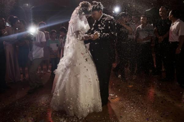 Ett uiguriskt par dansar sin första bröllopsdans, 2 augusti 2014 i Kashgar, i den autonoma regionen Xinjiang i västra Kina. Enligt ett nytt förslag ska giftermål mellan medlemmar av han, den dominerande etniciteten i Kina, och etniska minoriteter som uigurer uppmuntras med olika förmåner.(Kevin Frayer/Getty Images)