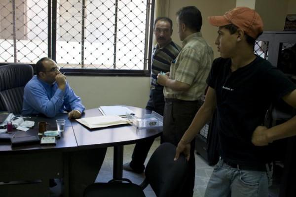 UNRWA:s representant Ibrahim Jaber samtalar med kunder i sitt kontor i Nablus, på Västbanken. (Foto: Genevieve Long/The Epoch Times)
