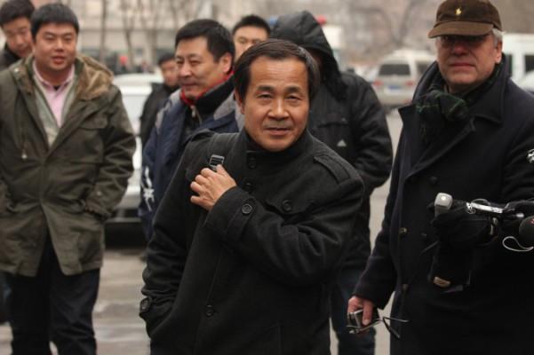 Advokat Cheng Hai (mitten) med civilklädda poliser och reportrar utanför ett tingshus i Peking, där han företrädde den kinesiska människorättsaktivisten Ni Yulan den 29 december 2011. (Foto: Ed Jones/AFP/Getty Images)