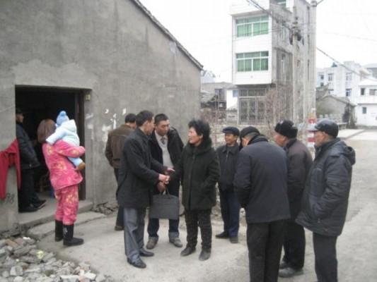 På detta foto ser man Wei Shuishan och Xue Mingkai (mitten, klädd i ljus tröja), två viktiga medlemmar i Kinas demokratiska parti, besöka Zhaiqiaos by för att intervjua familjen till en byledare som dog under mystiska omständigheter, Qian Yunhui, den 25 januari 2010. Den 29 januari 2013 dog Xue Mingkais far också under mystiska omständigheter som aktivister vill undersöka. (Foto: Med tillstånd från en aktivist)