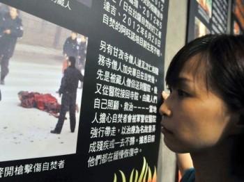 En volontär tittar på en bild av ett självbränningsoffer i Tibet den 29 juni 2012, under en utställning arrangerad av Amnesty i Tapei, Taiwan. Kinesisk polis har nyligen utfäst en belöning för de som lämnar uppgifter om planerade självbränningar. (Mandy Cheng/AFP/Getty Images)
