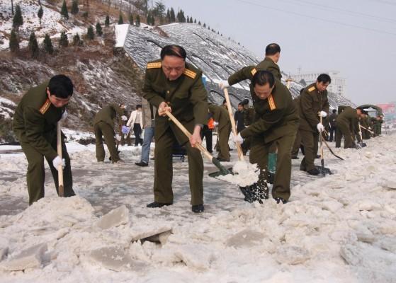 Soldater ur armén hjälper till med att skotta snö i Hunanprovinsen. Regimen har mobiliserat närmare en halv miljon soldater från armén och säkerhetsstyrkor i kampen mot  snömassorna efter veckor av snö och kyla. (AFP PHOTO CHINA OUT GETTY OUT)
