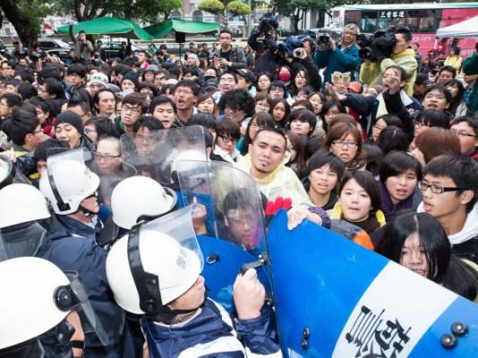 Medlemmar av Anti-Media Monopoly Youth Federation protesterade mot Want Want framför Taiwans regeringsbyggnad och utmanade polisen. De krävde att premiärminister Sean Chen skulle komma ut och lyssna på deras krav. (Foto: Chen Baizhou/The Epoch Times)
