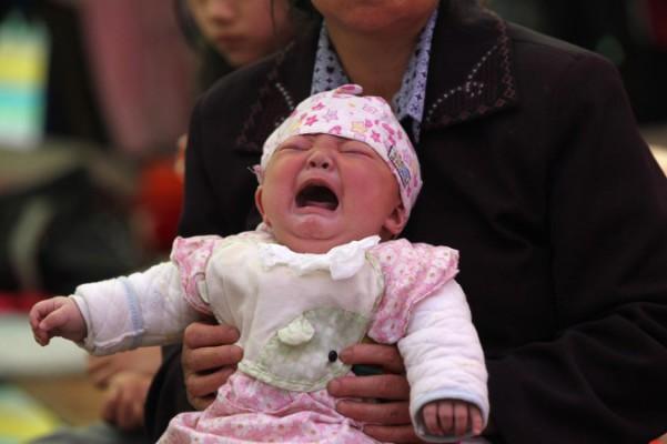 Ett litet barn och hennes mamma i Kina i april 2013. Kinesisk polis avslöjade nyligen en grupp som köpte och sålde 10 barn under 3 år i Shandongprovinsen. (Foto: AFP/Getty Images)
