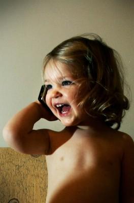 Ett barn låtsas prata med sin mormor i en mobiltelefon i London 11 januari 2005. Föräldrar i Storbritannien uppmanades då att begränsa barnens mobilanvändning efter att Sir William Stewarts studie visat att man inte kunde utesluta hälsorisker. (Foto: Adrian Dennis / AFP)