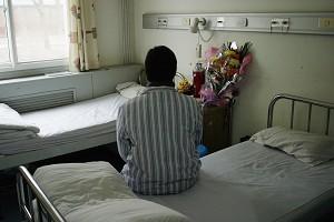 Anonym patient från Henanprovinsen som infekterades med HIV då hon sålde blod, sitter på sin säng på You' an-sjukhuset i Peking. Det är en av få platser i Kina där AIDS-patienter får mediciner. (Foto: Getty Images)