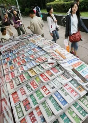 Kinesiska shoppare passerar en kiosk som säljer inhemska kinesiska nyhetstidningar vid Folkets Torg i Shanghai. Enligt det Hongkongbaserade Informationscentret för mänskliga rättigheter och demokrati har Kina ytterligare stramat åt mediekontrollen när det drar ihop sig för KKP:s 17:e nationalkongress. (Foto: Mark Ralston/AFP/ Getty Images)