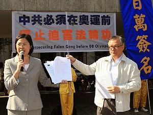 Zhu Wanqi (till vänster), talesperson för Falun Gong, presenterar ett brev för att samla namnunderskrifter i kampanjen. (Li Ming/The Epoch Times)
