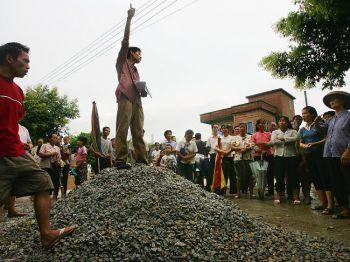 Demokrati: En bybo står på en stenhög och talar om korruptionen bland ledarna för bykommittén vid ett möte i byn Taishi i Guangdongprovinsen i Kina den 21 juli 2005. (Foto: China Photos/Getty Images)