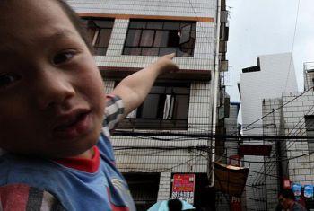 Efter jordbävningen den 30 augusti. Ett barn pekar på en märkbart lutande byggnad. (Foto: The Epoch Times)