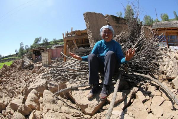 En kvinna gråter på sitt sammanrasade hus i bydistriktet Hetuo i Gansuprovinsen, 22 juli 2013. Dubbla jordskalv dödade 73 personer och skadade nästan 600, enligt myndigheterna. (Foto: STR/AFP/Getty Images)
