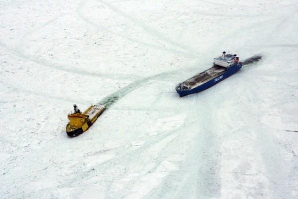 Ett fraktfartyg får assistans av en isbrytare som suttit fast i Östersjöns is. Omkring 50 fartyg var fångade i isen, en del av dem har suttit fast i flera dagar, men fick hjälp idag. (Foto: Svenska kustbevakningen / AFP)