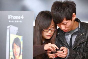 Kunder känner på en ny iPhone 4  i en nyöppnad Apple-affär i Peking. IPhonekopian "SoPhone4" får allt större dragningskraft i Kina. (Foto: Feng Li/Getty Images)