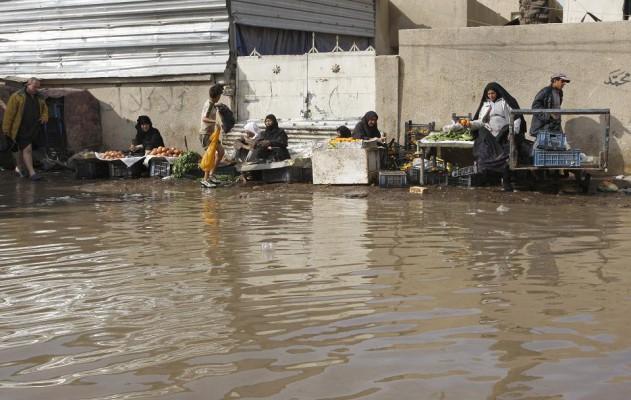 Frukt- och grönsaksstånd uppställda vid vattnets kanter i det översvämmade Bhagdads östra delar. (Foto: AFP / Ali Al-Saadi )