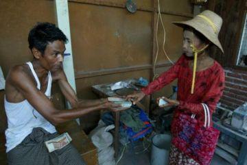 En burmesisk kvinna köpslår om sina jadestenar med en butiksinnehavare på jademarknaden i Mandalay, Burma. Landet genererar en ansenlig inkomst från de värdefulla stengruvorna, de flesta belägna i Burmas norra delar. (Foto: Paula Bronstein/Getty Images)