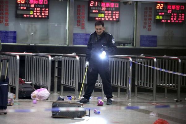 En kinesisk polis undersöker platsen för angreppet, tågstationen i Kunming i Yunnanprovinsen i sydvästra Kina, den 2 mars 2014, dagen efter att 10 angripare högg ihjäl 29 personer och skadade över 140. (STR/AFP/Getty Images)
