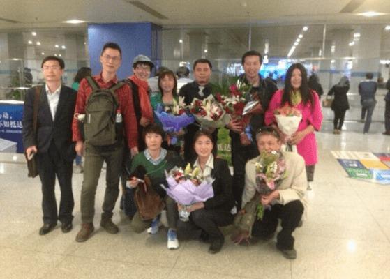 Kineser välkomnar advokaterna Tang Jitian (längst bak, andra från höger) och Wang Chen (längst bak, tredje från höger) på flygplatsen i Peking den 6 april. Tre människorättsadvokater släpptes i söndags efter att ha suttit frihetsberövade i två veckor i ett arbetsläger i den nordliga Heilongjiangprovinsen. (Foto: Twitter)