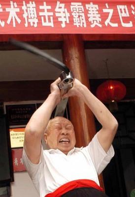 Tang Lixian slår sig själv i huvudet flera gånger med en tre kilos järnstång. (Foto: Epoch Times Arkiv)
