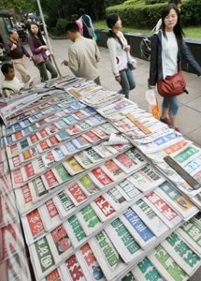 Folk går förbi en kiosk som säljer kinesiska tidningar i Shanghai. Kritiker har varnat för att mediacensuren i Kina inte är förenlig med uppbyggnaden av en marknadsekonomi. Censur och propaganda är dock väsentliga i kommunistpartiets styre. (Foto: Mark Ralston/AFP/Getty Images)