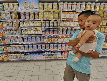 Förälder och barn bland hyllor med mjölkpulver till extrapris på en stormarknad i Hefei i Anhuiprovinsen, 26 september 2010. Kina har ökat sin övervakning när det gäller melamin, den giftiga kemikalie som ledde till sex spädbarns död i mjölkskandalen 2008. (Foto: STR/AFP/Getty Images)