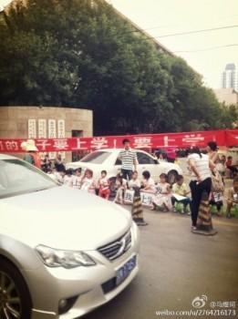 Barn protesterar framför Fengtaidistriktets utbildningsnämnd i Peking den 13 juni. Barnen sitter på pallar och ropar: ”Jag vill gå i skolan.” (Foto från Weibo.com)